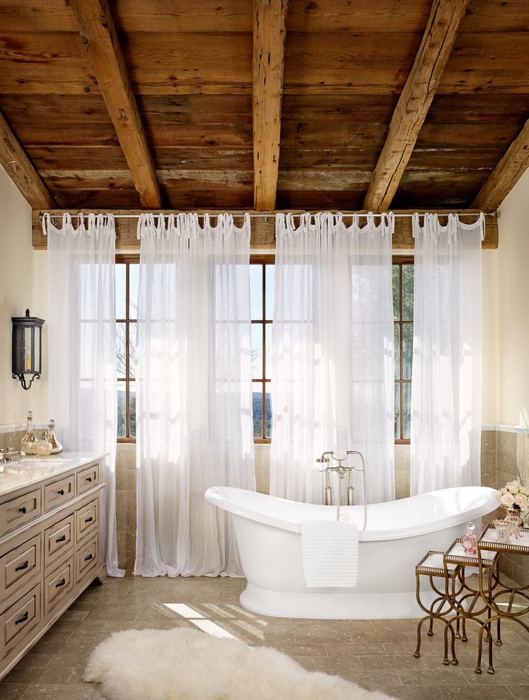 Idee per una stanza da bagno mediterranea con ante grigie, vasca freestanding, piastrelle grigie, pareti bianche e lavabo sottopiano