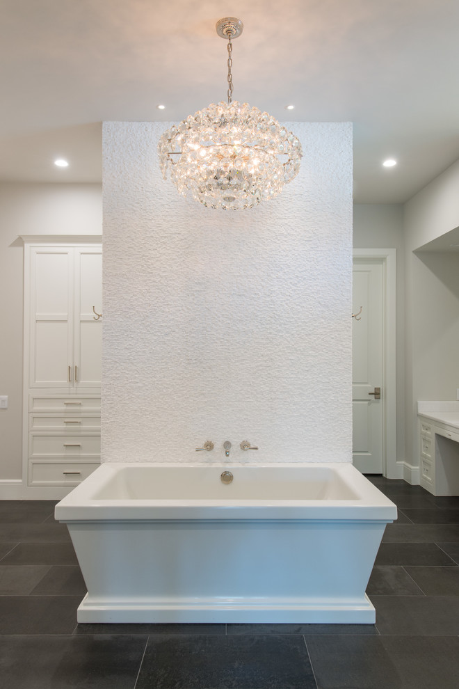 На фото: огромная главная ванная комната в стиле неоклассика (современная классика) с врезной раковиной, фасадами с утопленной филенкой, белыми фасадами, столешницей из кварцита, отдельно стоящей ванной, двойным душем, унитазом-моноблоком, белой плиткой, каменной плиткой, серыми стенами и полом из известняка