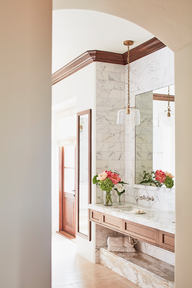Bild på ett stort medelhavsstil vit vitt en-suite badrum, med luckor med infälld panel, skåp i mörkt trä, ett fristående badkar, en dubbeldusch, grå kakel, marmorkakel, vita väggar, kalkstensgolv, ett undermonterad handfat, marmorbänkskiva, beiget golv och dusch med gångjärnsdörr