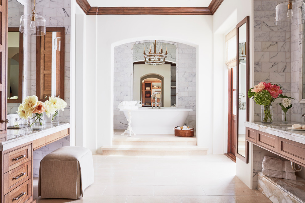 На фото: большая главная ванная комната в средиземноморском стиле с фасадами с утопленной филенкой, темными деревянными фасадами, отдельно стоящей ванной, серой плиткой, мраморной плиткой, белыми стенами, врезной раковиной, бежевым полом, двойным душем, полом из известняка, мраморной столешницей, душем с распашными дверями и белой столешницей