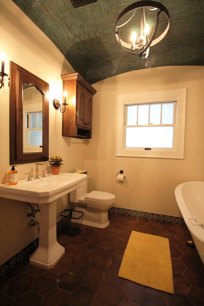 Photo of a medium sized ensuite bathroom in Sacramento with raised-panel cabinets, medium wood cabinets, a claw-foot bath, a two-piece toilet, multi-coloured tiles, porcelain tiles, beige walls, porcelain flooring and a pedestal sink.