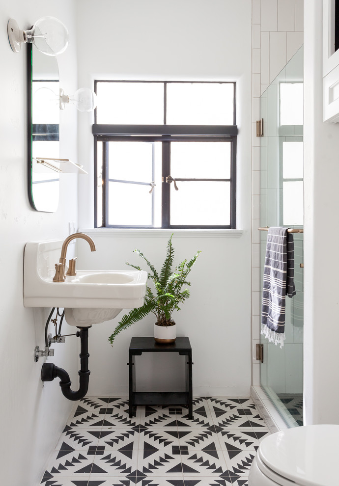 Imagen de cuarto de baño mediterráneo con paredes blancas, suelo de azulejos de cemento, lavabo suspendido, suelo multicolor, ducha empotrada, aseo y ducha y ducha con puerta con bisagras