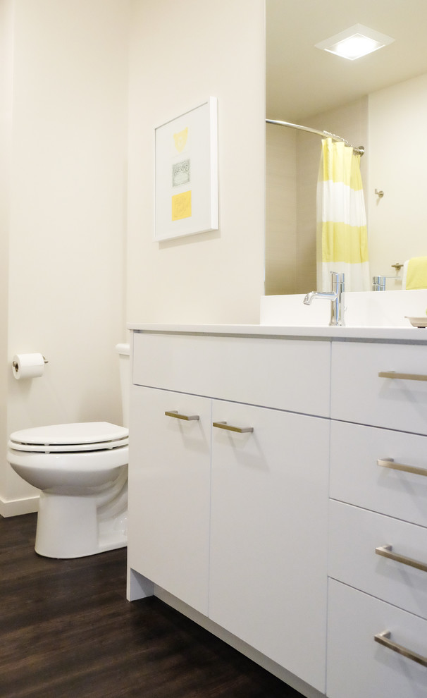 Foto på ett litet funkis badrum, med släta luckor, vita skåp, vinylgolv och brunt golv