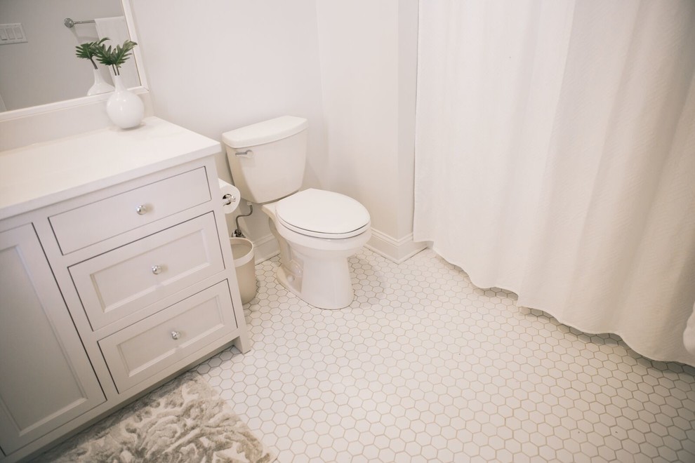 Пример оригинального дизайна: ванная комната среднего размера в стиле неоклассика (современная классика) с белой плиткой, керамогранитной плиткой, полом из керамогранита, фасадами в стиле шейкер, белыми фасадами, ванной в нише, душем над ванной, унитазом-моноблоком, белыми стенами, душевой кабиной, врезной раковиной и столешницей из искусственного камня