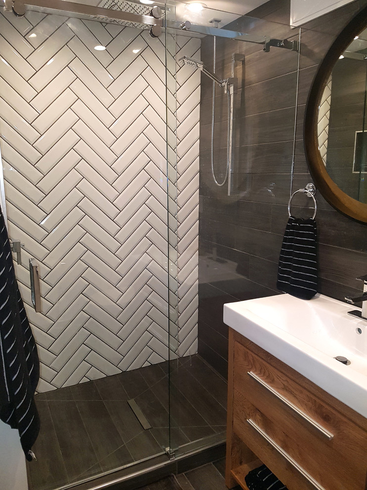 Medium sized modern bathroom in Toronto with freestanding cabinets, brown cabinets, an alcove shower, a two-piece toilet, black tiles, ceramic tiles, white walls, porcelain flooring, a vessel sink, solid surface worktops, black floors, a sliding door and white worktops.
