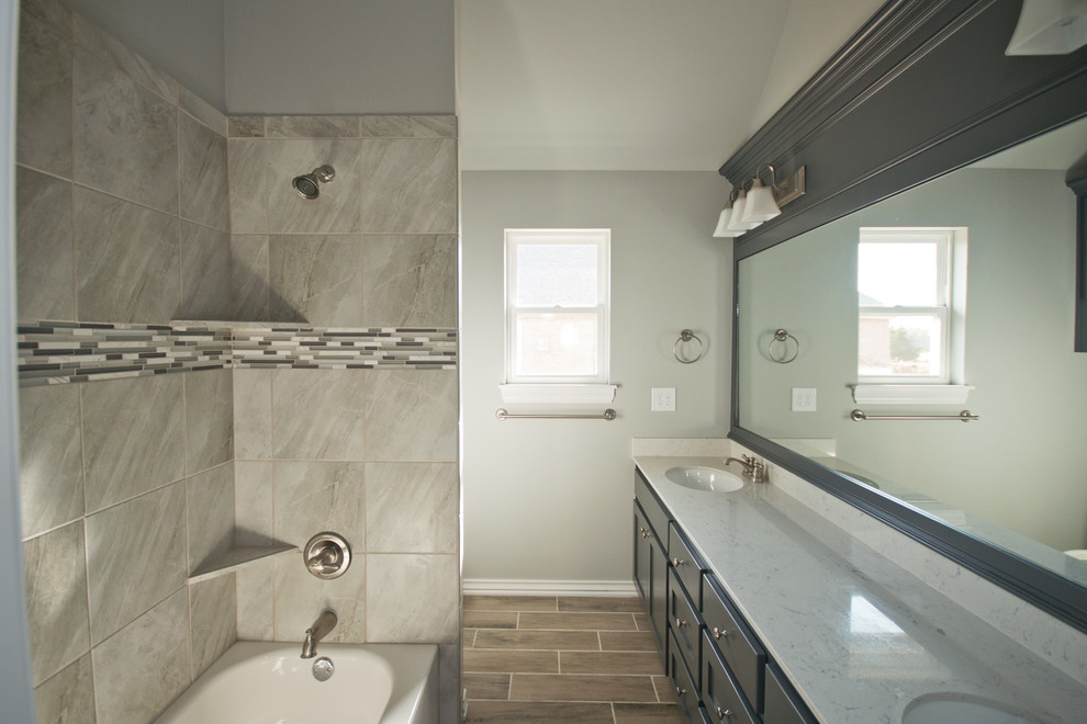 Bathroom - mid-sized transitional gray tile and ceramic tile ceramic tile bathroom idea in Oklahoma City with shaker cabinets, blue cabinets, a one-piece toilet, gray walls, an undermount sink and marble countertops
