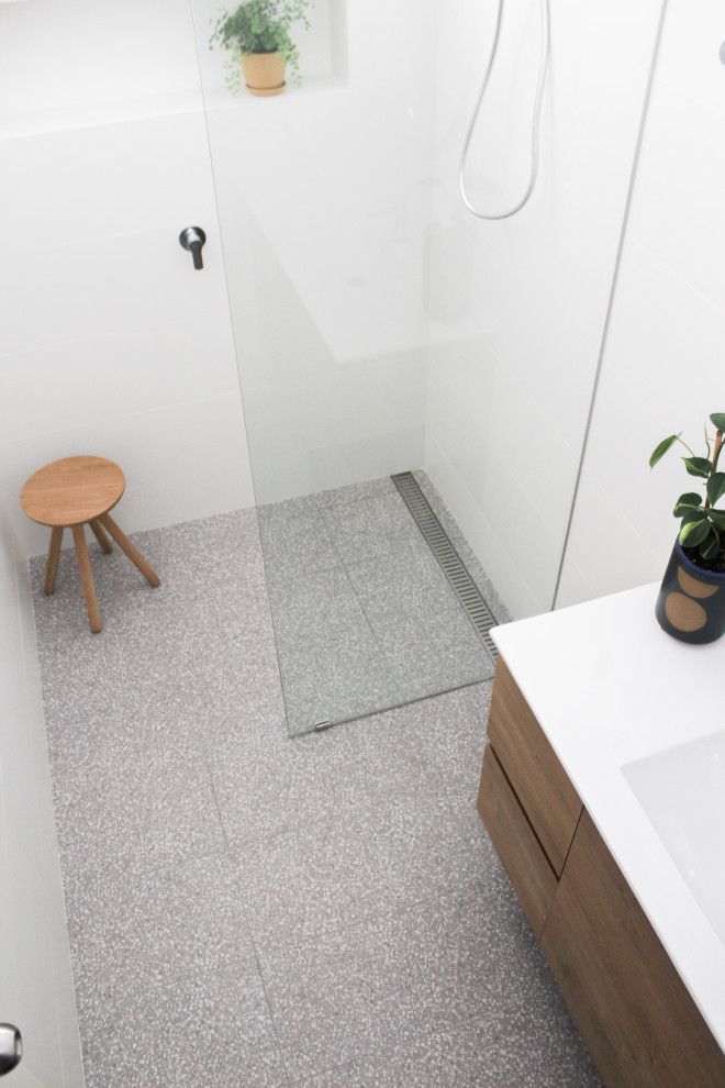 Bathroom - mid-sized kids' white tile and ceramic tile terrazzo floor, gray floor and single-sink bathroom idea in Perth with flat-panel cabinets, dark wood cabinets, white walls, an integrated sink, solid surface countertops, white countertops and a floating vanity