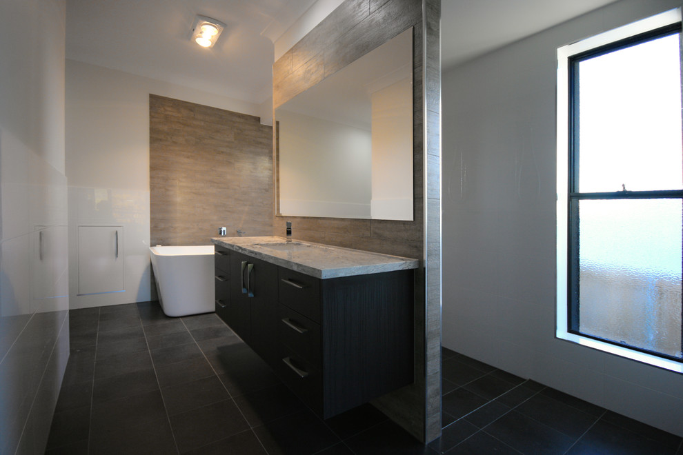 Example of a large trendy master brown tile and ceramic tile ceramic tile bathroom design in Brisbane with an undermount sink, flat-panel cabinets, dark wood cabinets, granite countertops, a wall-mount toilet and white walls