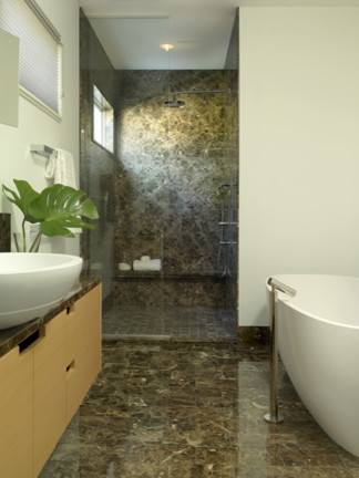 Idée de décoration pour une douche en alcôve principale minimaliste en bois clair avec un placard à porte plane, une baignoire indépendante, un carrelage marron et un plan de toilette en marbre.