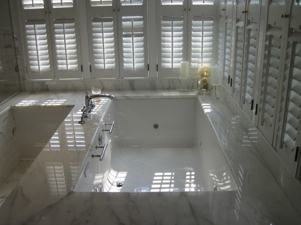 Idee per una stanza da bagno tradizionale con lavabo sottopiano, consolle stile comò, ante bianche, top in marmo, vasca sottopiano, doccia ad angolo, WC a due pezzi, piastrelle bianche e piastrelle in pietra