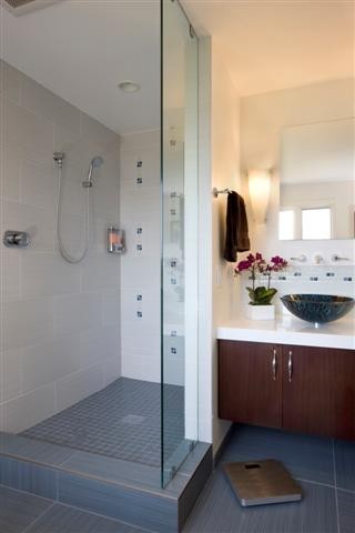 Large contemporary bathroom in San Francisco with a vessel sink, flat-panel cabinets, medium wood cabinets, engineered stone worktops, a freestanding bath, a walk-in shower, a two-piece toilet, multi-coloured tiles, porcelain tiles, white walls and porcelain flooring.
