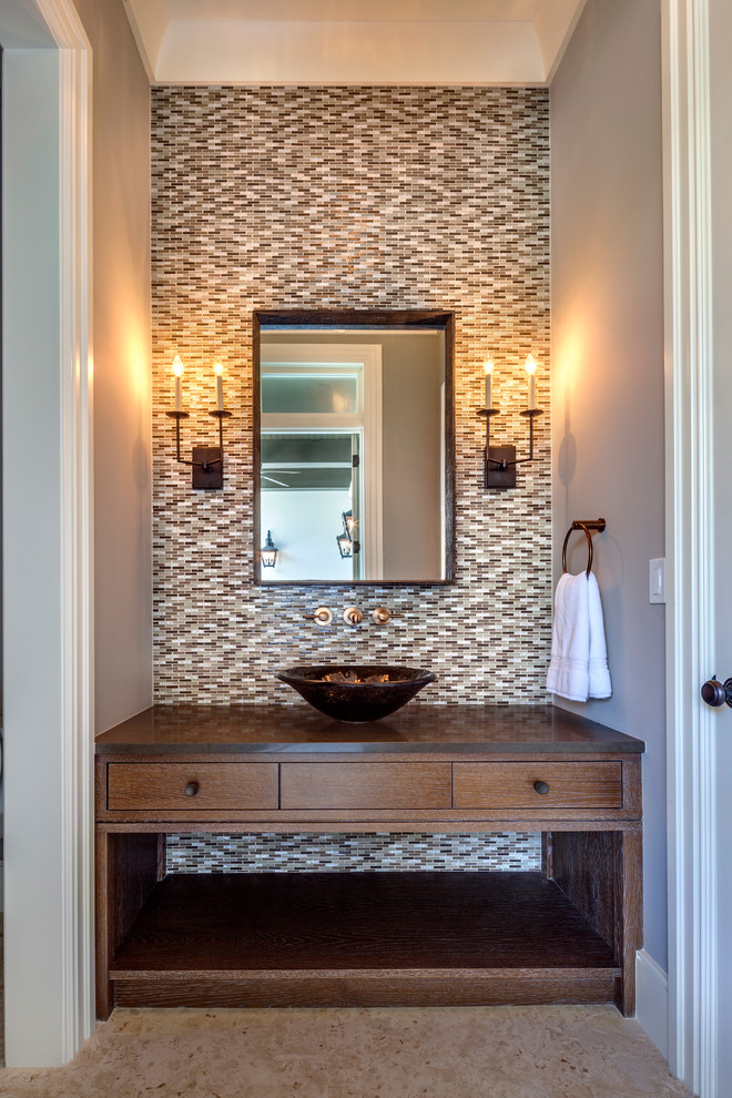 タンパにあるトロピカルスタイルのおしゃれな浴室 (ベッセル式洗面器、濃色木目調キャビネット、マルチカラーのタイル) の写真