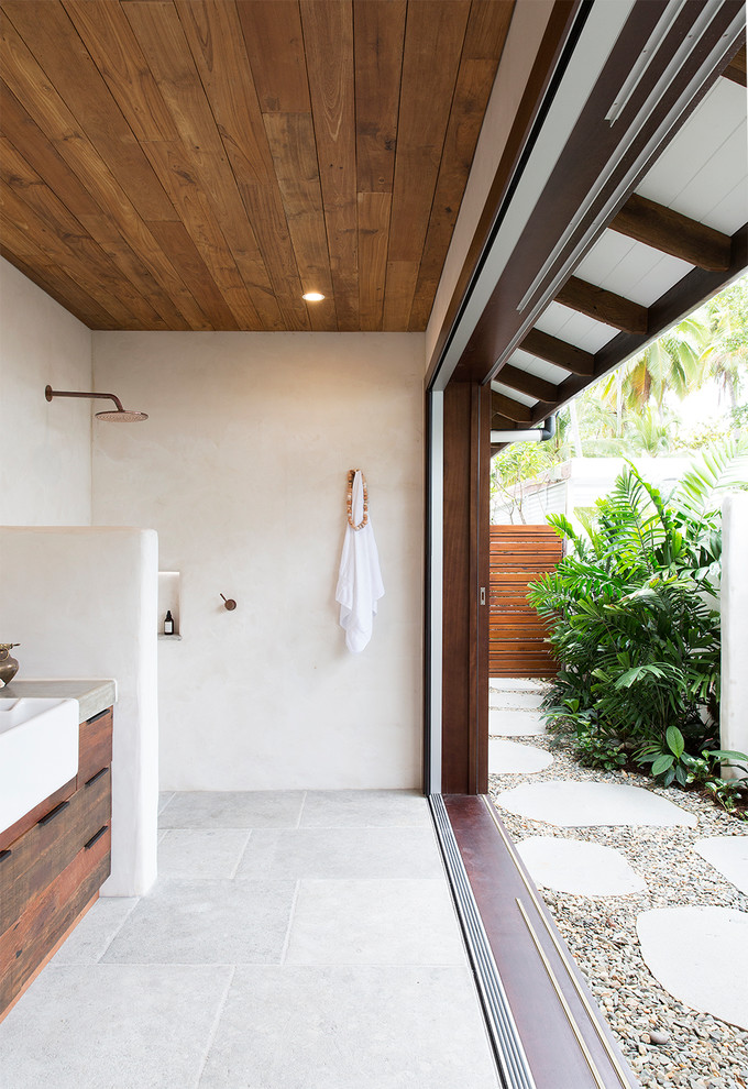 Aménagement d'une salle d'eau exotique en bois vieilli avec un placard à porte plane, une douche ouverte, un mur blanc, un sol gris et aucune cabine.