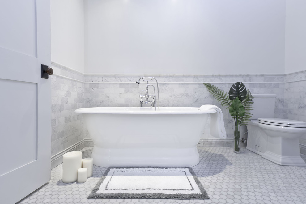 Inspiration for a large urban ensuite bathroom in New York with a freestanding bath, a corner shower, grey tiles, marble tiles, white walls, a pedestal sink, marble worktops and a hinged door.