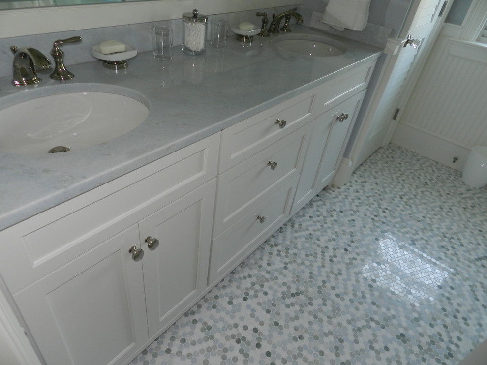 Inredning av ett maritimt mellanstort badrum, med skåp i shakerstil, vita skåp, en öppen dusch, en toalettstol med separat cisternkåpa, vit kakel, tunnelbanekakel, blå väggar, ett undermonterad handfat och marmorbänkskiva
