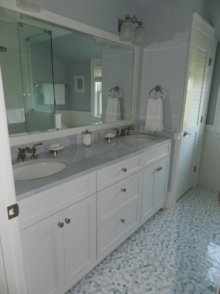 Inredning av ett maritimt mellanstort badrum, med skåp i shakerstil, vita skåp, en öppen dusch, en toalettstol med separat cisternkåpa, vit kakel, tunnelbanekakel, blå väggar, ett undermonterad handfat och marmorbänkskiva