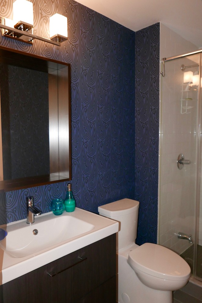 Immagine di una stanza da bagno con doccia chic di medie dimensioni con ante in legno bruno, doccia alcova, WC monopezzo, piastrelle bianche, piastrelle in gres porcellanato, pareti blu, lavabo integrato, top in superficie solida e porta doccia scorrevole