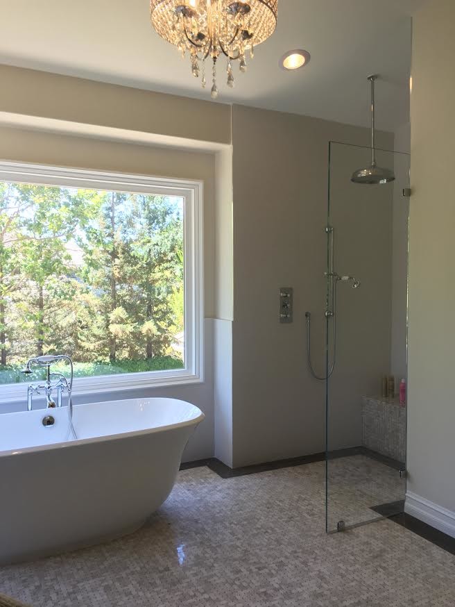 This is an example of a medium sized traditional ensuite bathroom in Los Angeles with a freestanding bath, a walk-in shower, beige tiles, ceramic tiles, beige walls, ceramic flooring, a built-in sink, beige floors and an open shower.