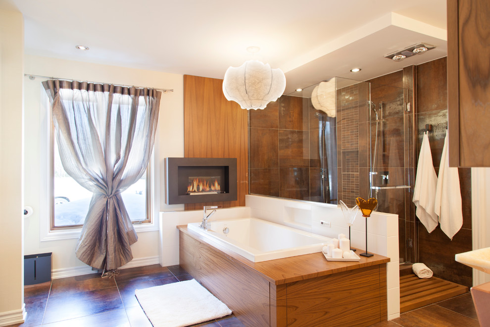 モントリオールにあるコンテンポラリースタイルのおしゃれな浴室 (フラットパネル扉のキャビネット、中間色木目調キャビネット、ドロップイン型浴槽、コーナー設置型シャワー、茶色いタイル) の写真