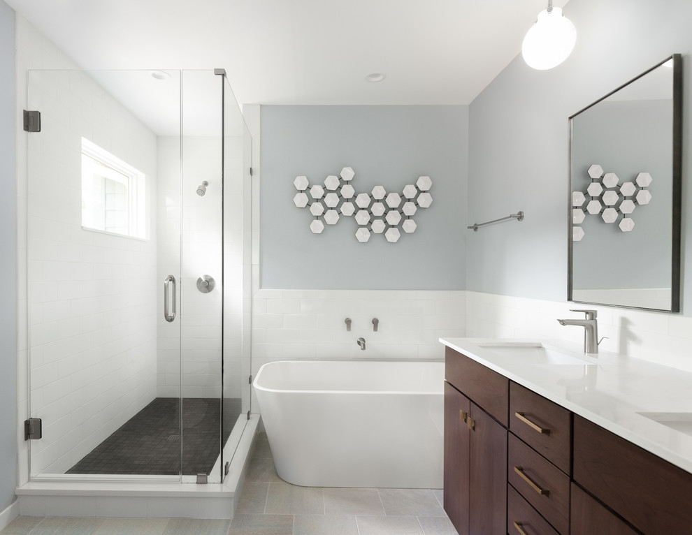 Идея дизайна: маленькая главная ванная комната в современном стиле с плоскими фасадами, коричневыми фасадами, отдельно стоящей ванной, душем в нише, унитазом-моноблоком, белой плиткой, керамической плиткой, синими стенами, полом из керамогранита, врезной раковиной, столешницей из искусственного камня, серым полом, душем с распашными дверями, белой столешницей, нишей, тумбой под две раковины и подвесной тумбой для на участке и в саду
