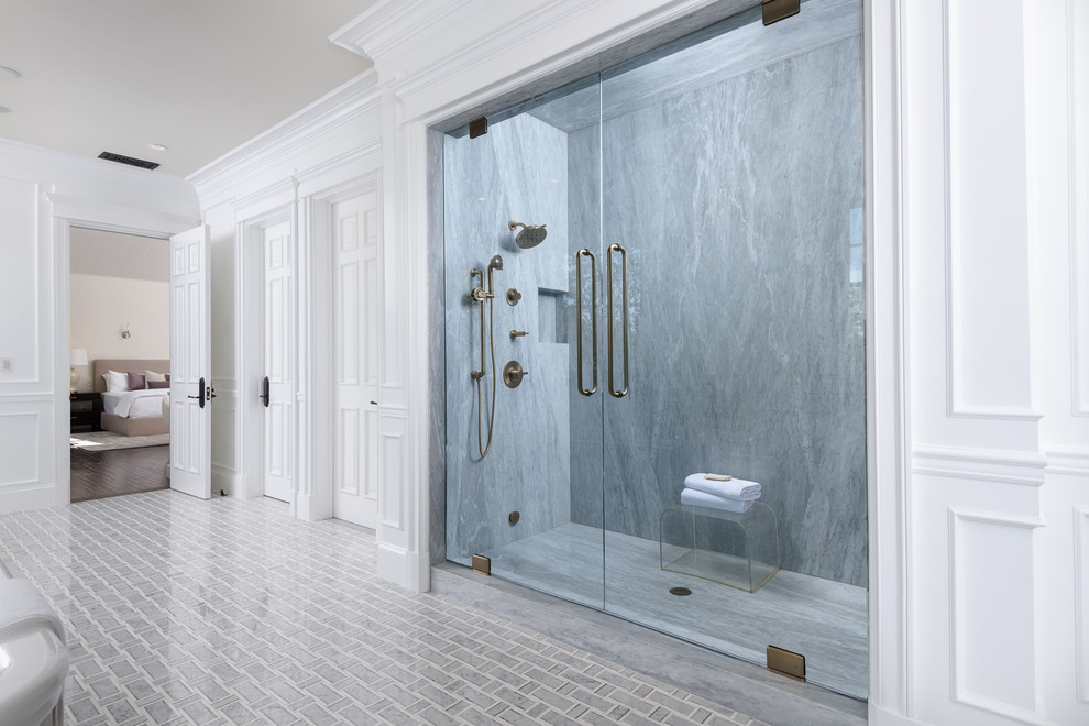 Источник вдохновения для домашнего уюта: огромная главная ванная комната в стиле неоклассика (современная классика) с фасадами островного типа, белыми фасадами, отдельно стоящей ванной, душем в нише, серой плиткой, плиткой из листового камня, белыми стенами, врезной раковиной, мраморной столешницей, разноцветным полом, душем с распашными дверями и серой столешницей