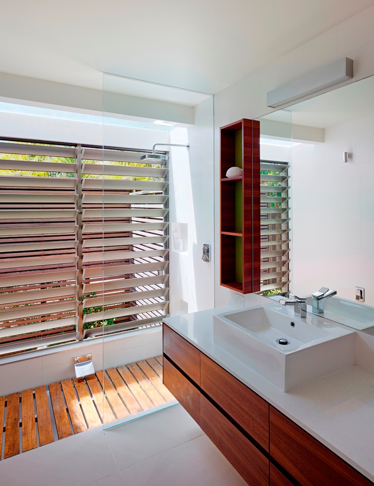 Foto de cuarto de baño rectangular contemporáneo con lavabo sobreencimera, armarios con paneles lisos, puertas de armario de madera oscura, paredes blancas y ducha a ras de suelo