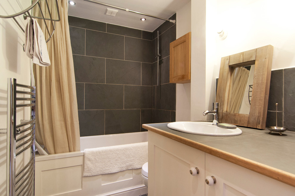 Design ideas for a small family bathroom in Edinburgh with shaker cabinets, beige cabinets, a built-in bath, a shower/bath combination, a one-piece toilet, grey tiles, stone slabs, white walls, slate flooring, tiled worktops and an integrated sink.