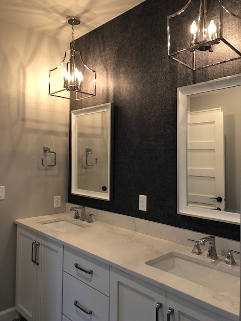 Cette image montre une salle de bain principale traditionnelle avec des portes de placard blanches, un mur gris et un plan de toilette en granite.