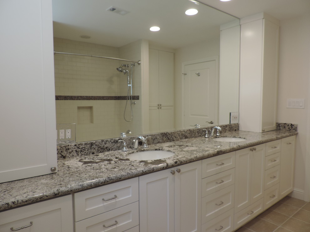 Example of a transitional master beige tile porcelain tile alcove shower design in Houston with an undermount sink, flat-panel cabinets, white cabinets, granite countertops and white walls