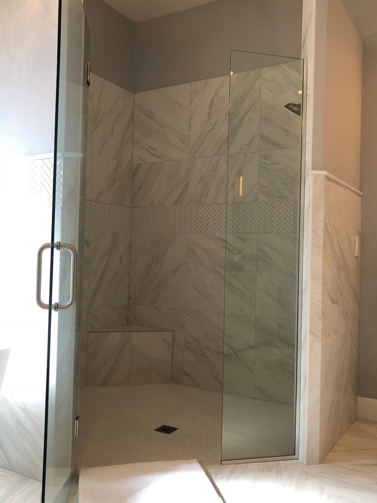 Пример оригинального дизайна: главная ванная комната среднего размера в стиле неоклассика (современная классика) с белыми фасадами, отдельно стоящей ванной, угловым душем, раздельным унитазом, белой плиткой, мраморной плиткой, серыми стенами, мраморным полом, врезной раковиной, серым полом и душем с распашными дверями