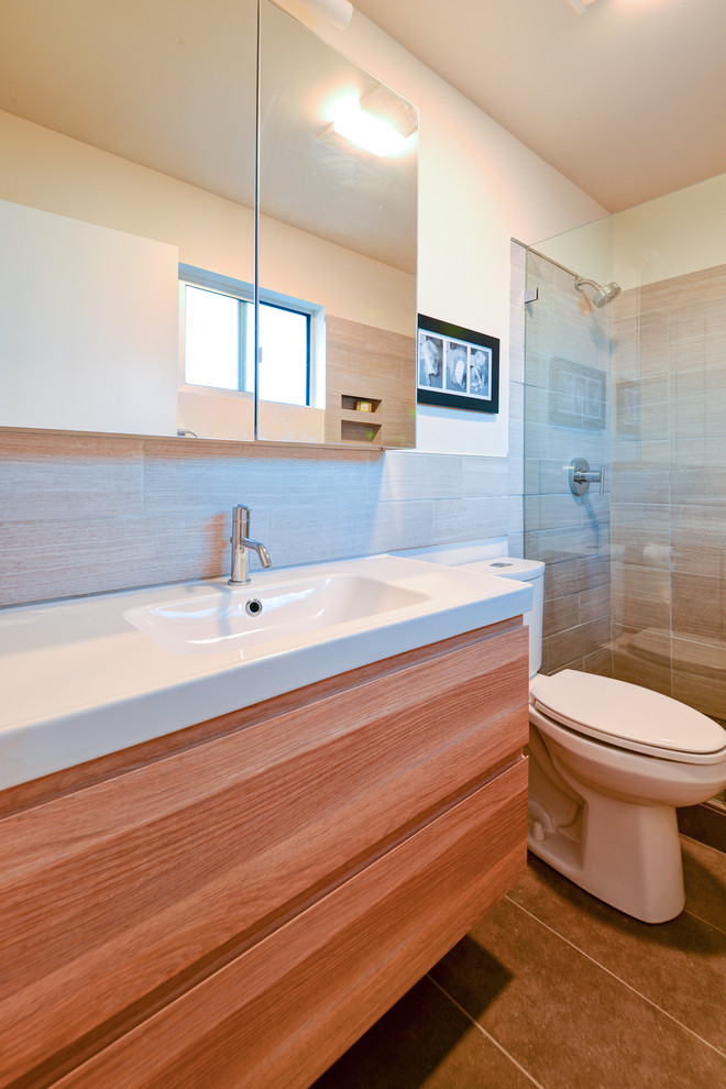 Kleines Mid-Century Badezimmer mit integriertem Waschbecken, Duschnische, Wandtoilette mit Spülkasten, flächenbündigen Schrankfronten, hellbraunen Holzschränken, grauen Fliesen, Keramikfliesen, weißer Wandfarbe und Keramikboden in Austin