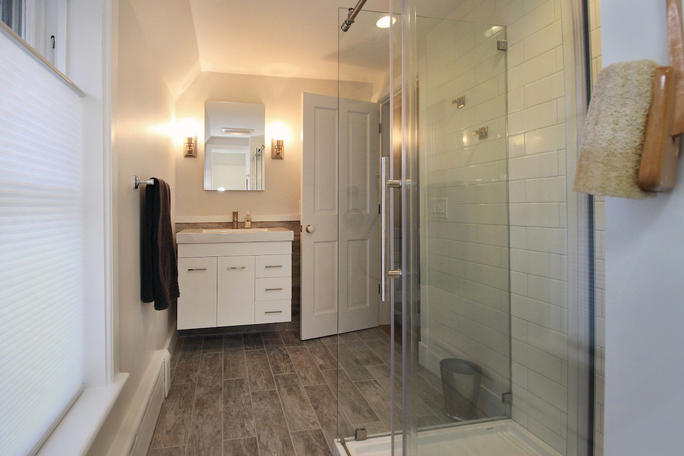 Réalisation d'une salle de bain minimaliste de taille moyenne avec une douche d'angle, WC à poser, un carrelage blanc, un carrelage métro, un mur blanc, un sol en carrelage de céramique et un lavabo intégré.