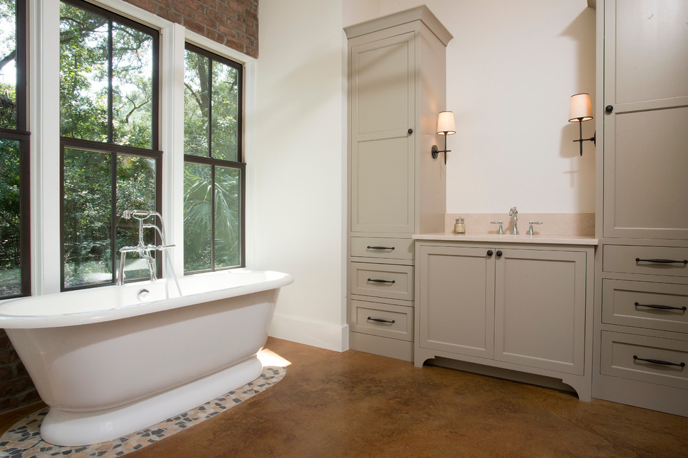 Пример оригинального дизайна: главная ванная комната среднего размера в классическом стиле с врезной раковиной, фасадами с утопленной филенкой, серыми фасадами, столешницей из гранита, отдельно стоящей ванной, бежевой плиткой, белыми стенами и бетонным полом