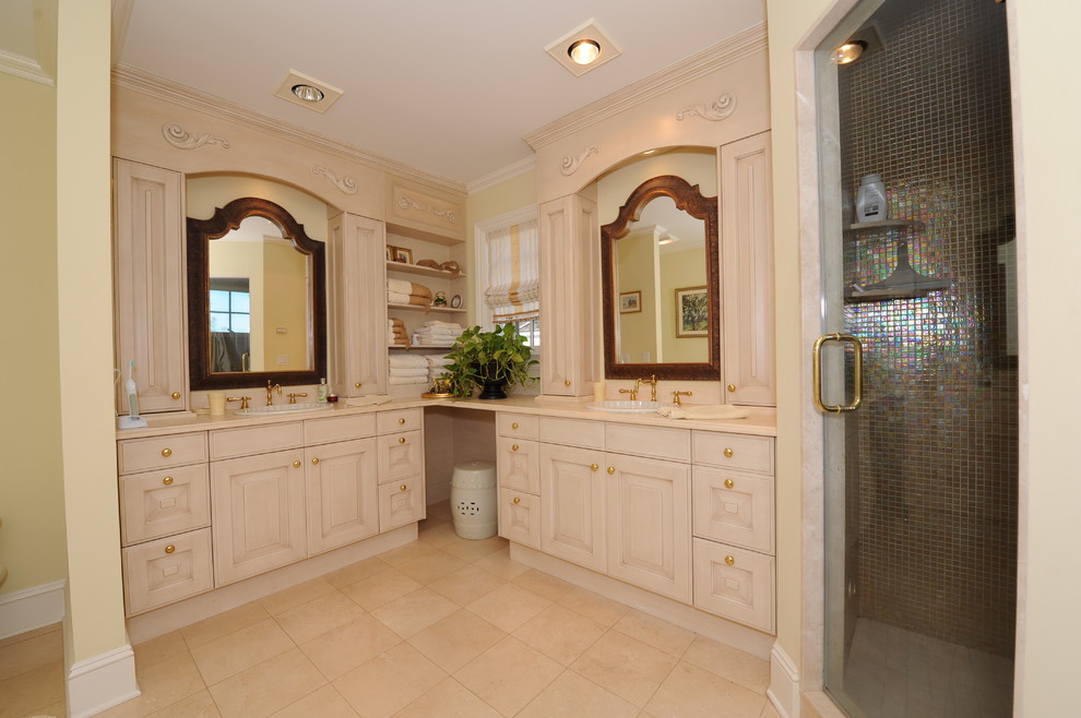 Cette photo montre une grande salle de bain principale chic avec un placard avec porte à panneau surélevé, des portes de placard beiges, une douche d'angle, un carrelage multicolore, mosaïque, un mur jaune, un sol en travertin, un lavabo posé, un plan de toilette en quartz modifié, un sol marron et une cabine de douche à porte battante.