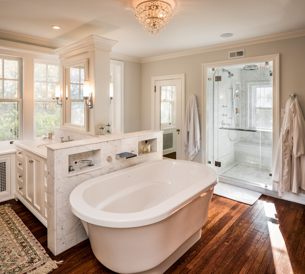 Inspiration for a classic ensuite bathroom in Philadelphia with recessed-panel cabinets, white cabinets, a freestanding bath, an alcove shower, grey walls, dark hardwood flooring, a submerged sink and a hinged door.