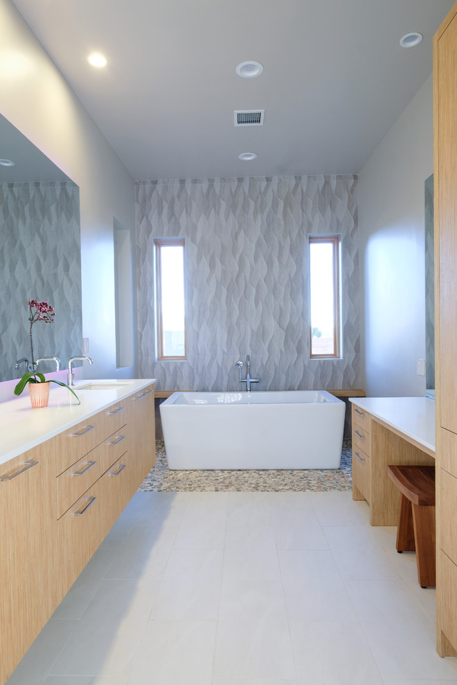 Идея дизайна: большая главная ванная комната в стиле модернизм с плоскими фасадами, светлыми деревянными фасадами, отдельно стоящей ванной, открытым душем, бежевой плиткой, белыми стенами, полом из керамогранита, врезной раковиной, столешницей из искусственного кварца, бежевым полом, открытым душем и белой столешницей