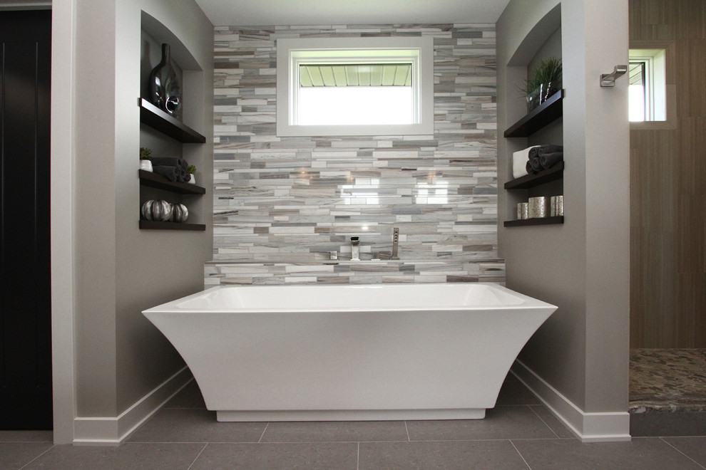 Bild på ett mellanstort grå grått en-suite badrum, med öppna hyllor, skåp i mörkt trä, ett fristående badkar, en dusch i en alkov, grå kakel, porslinskakel, grå väggar, klinkergolv i porslin, grått golv och med dusch som är öppen