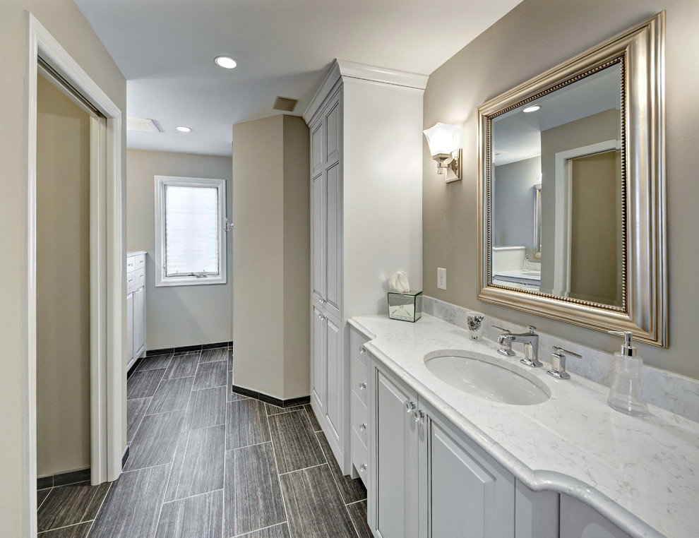 ミネアポリスにあるトラディショナルスタイルのおしゃれな浴室 (アンダーカウンター洗面器、レイズドパネル扉のキャビネット、クオーツストーンの洗面台、オープン型シャワー、分離型トイレ、グレーのタイル、磁器タイル) の写真