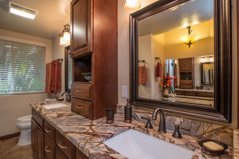Aménagement d'une salle de bain classique en bois brun avec un lavabo posé, un placard à porte plane, un plan de toilette en granite, une douche ouverte, WC à poser, un carrelage multicolore et un carrelage de pierre.