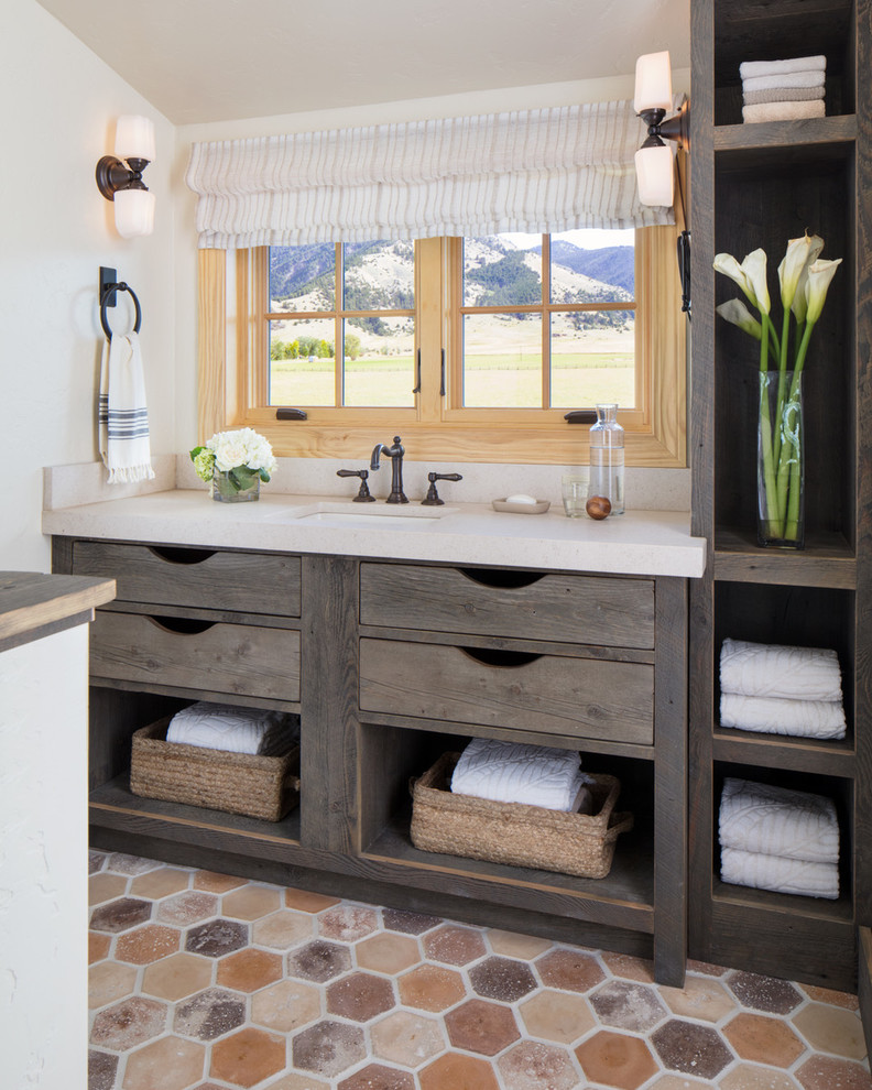 Photo of a rustic bathroom in Other with open cabinets, dark wood cabinets, a submerged sink, beige worktops, white walls and multi-coloured floors.