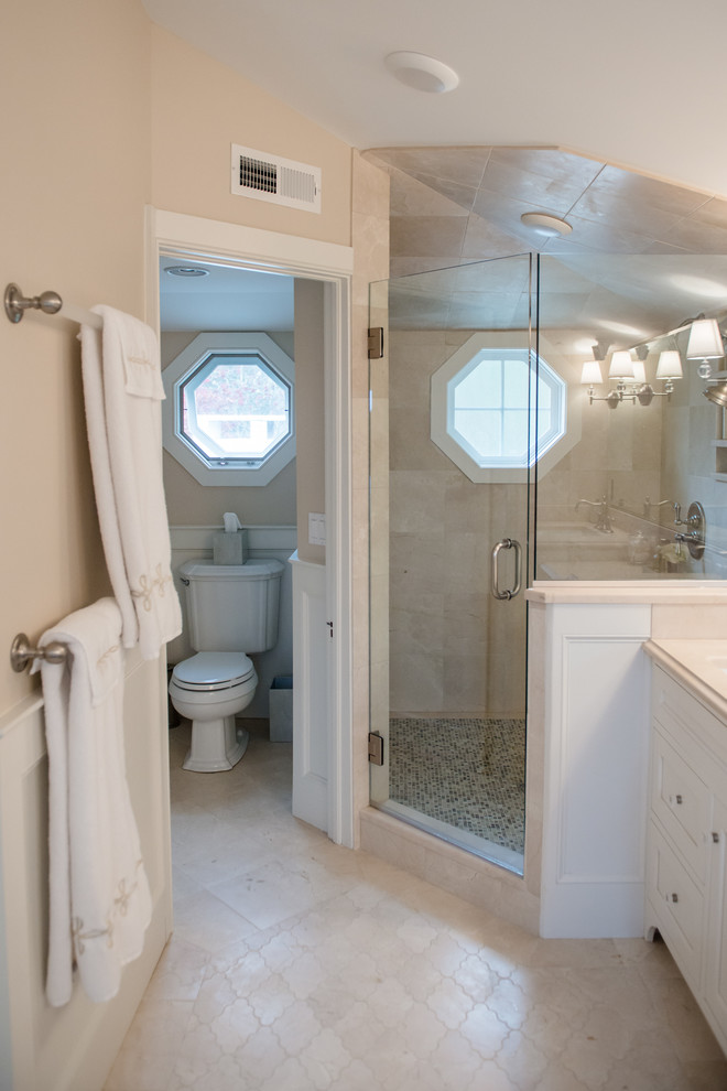 На фото: большая главная ванная комната в стиле неоклассика (современная классика) с фасадами в стиле шейкер, белыми фасадами, угловым душем, бежевыми стенами и полом из керамической плитки с