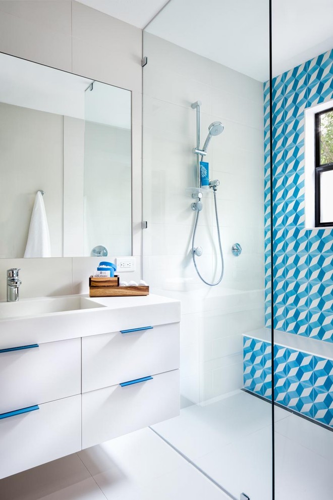 На фото: ванная комната среднего размера в современном стиле с синей плиткой, разноцветной плиткой, белой плиткой, цементной плиткой, плоскими фасадами, белыми фасадами, душем без бортиков, монолитной раковиной, белыми стенами, столешницей из искусственного камня, открытым душем и душевой кабиной с