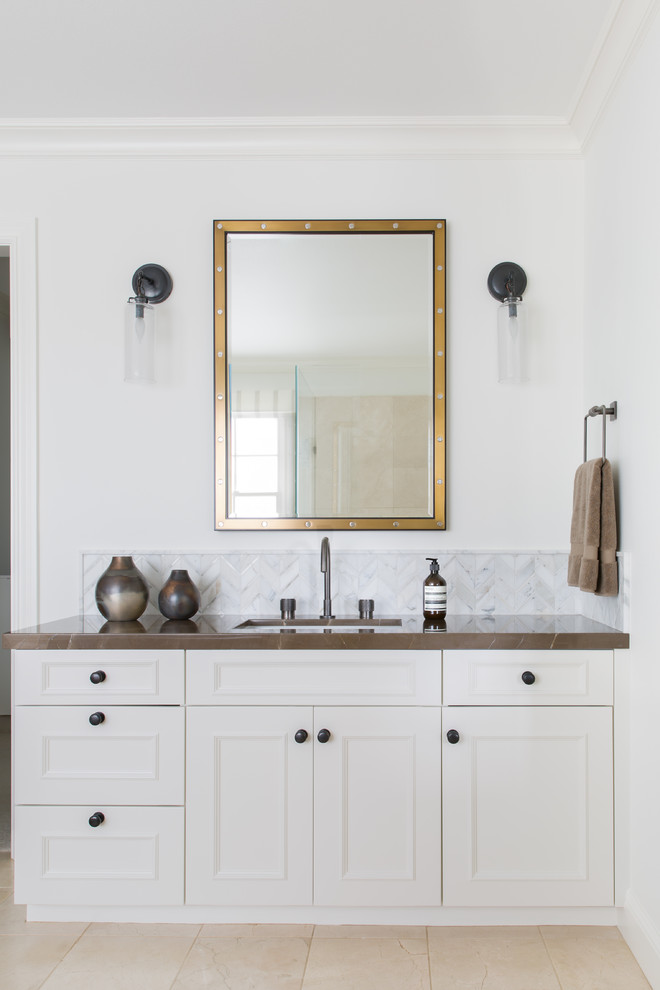 Inspiration för ett vintage brun brunt badrum, med luckor med infälld panel, vita skåp, vit kakel, marmorkakel, vita väggar, ett undermonterad handfat och beiget golv