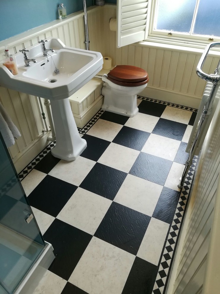 Ejemplo de cuarto de baño moderno con ducha esquinera, sanitario de una pieza, baldosas y/o azulejos azules, paredes grises, suelo vinílico y lavabo suspendido