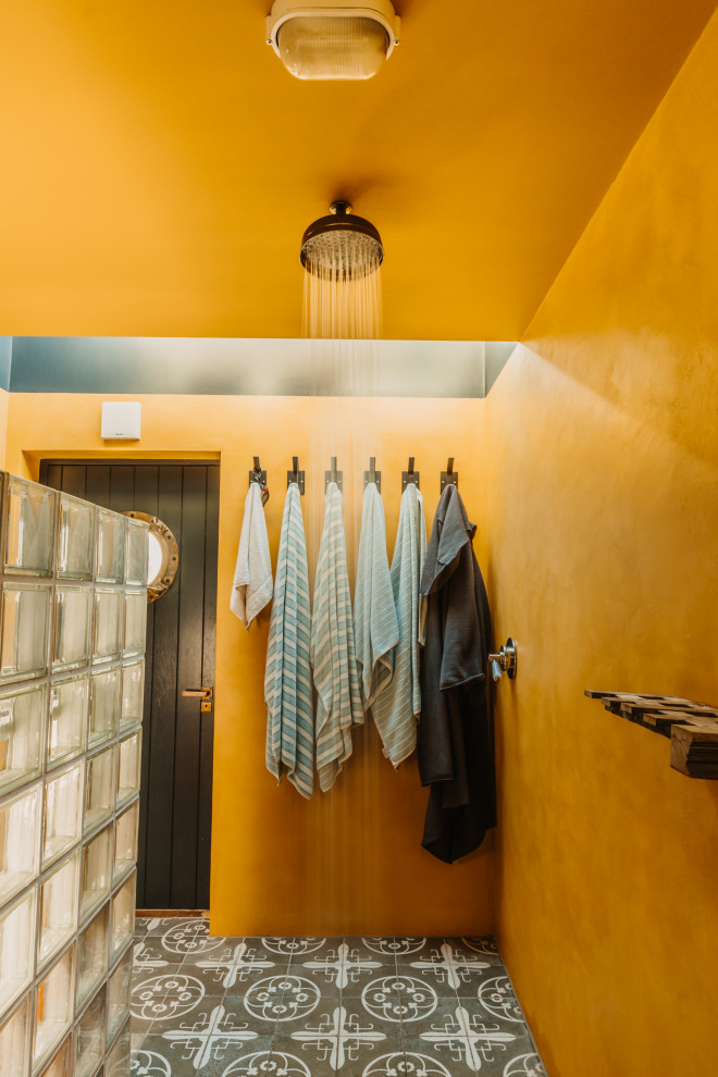 Esempio di una stanza da bagno con doccia costiera di medie dimensioni con pareti arancioni, pavimento in cementine e pavimento grigio