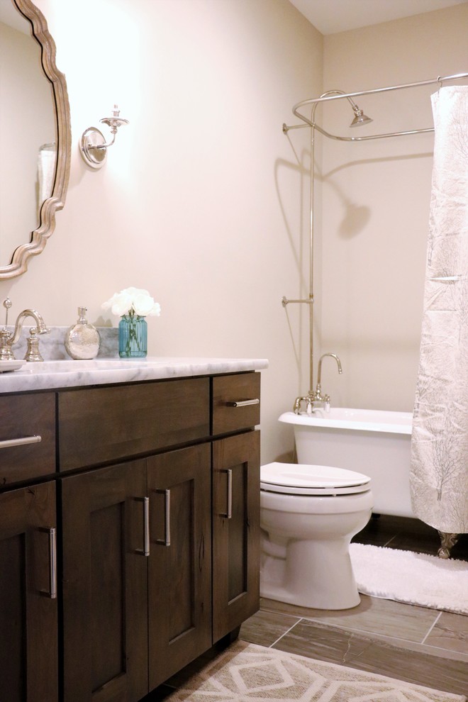 Kleines Klassisches Badezimmer mit Schrankfronten im Shaker-Stil, grauen Schränken, Toilette mit Aufsatzspülkasten, grauen Fliesen, Travertinfliesen, beiger Wandfarbe, dunklem Holzboden, integriertem Waschbecken und Marmor-Waschbecken/Waschtisch in St. Louis