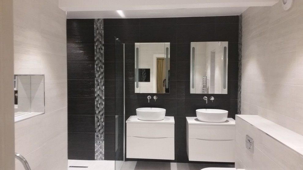 Exemple d'une grande salle de bain tendance avec un placard à porte plane, des portes de placard blanches, une baignoire indépendante, une douche ouverte, un carrelage noir, mosaïque et un sol en carrelage de porcelaine.