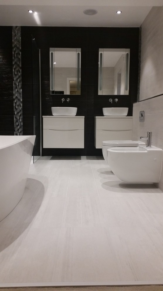 Idee per una grande stanza da bagno contemporanea con ante lisce, ante bianche, vasca freestanding, doccia aperta, bidè, piastrelle nere, piastrelle a mosaico e pavimento in gres porcellanato