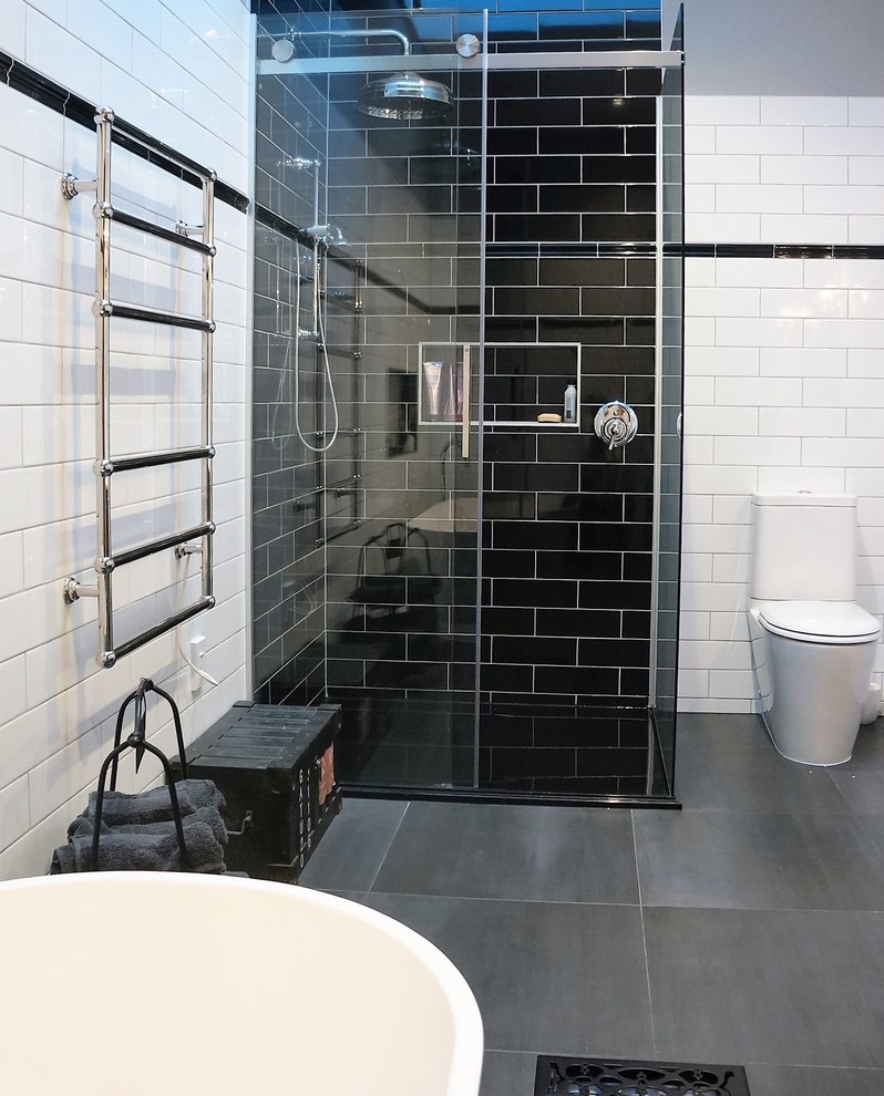 Foto de cuarto de baño principal clásico de tamaño medio con bañera exenta, baldosas y/o azulejos blancas y negros, baldosas y/o azulejos de cemento y suelo de baldosas de porcelana