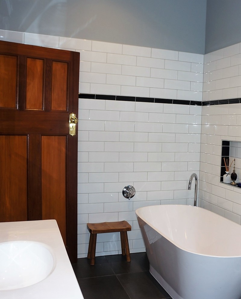 Modelo de cuarto de baño principal clásico de tamaño medio con bañera exenta, baldosas y/o azulejos blancas y negros, baldosas y/o azulejos de cemento y suelo de baldosas de porcelana